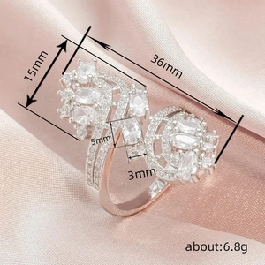 Luxury silver-tone winged statement ring with white zircons on pink satin background