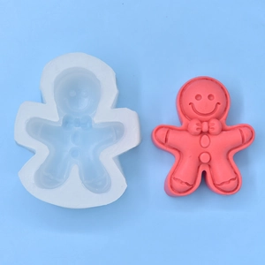 Detail of white silicone gingerbread man mold with red finished cake topper decoration