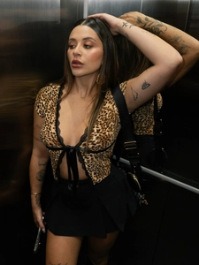 Detail of leopard print crop top with black lace trim and delicate ribbon tie front