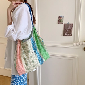 Floral canvas tote bag with drawstring closure shown over the shoulder on a model