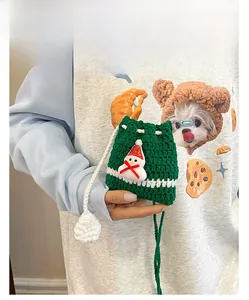 Detailed view of handmade green knitted drawstring bag with 3D snowman and white pom pom