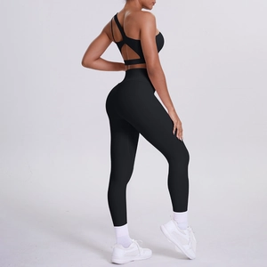 Detail of black one-shoulder yoga sports bra and high-waisted leggings set on model