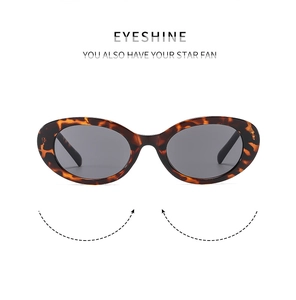 Detail of oval tortoiseshell sunglasses with dark lenses and vintage brown pattern