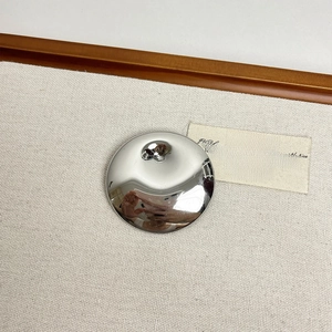 Detailed macro view of silver irregular round brooch with mirror polished metallic surface