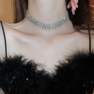 Detailed view of irregular silver-toned choker necklace with sparkling crystals on model