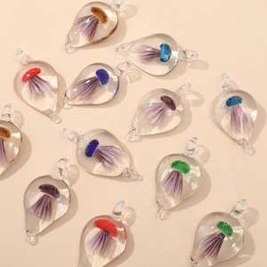 Macro detail of colorful teardrop glass pendants with jellyfish glass art inlay