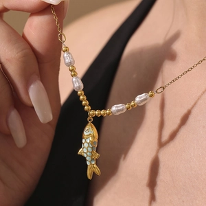 Golden koi fish pendant necklace featuring mixed pearls and beads on a sleek model