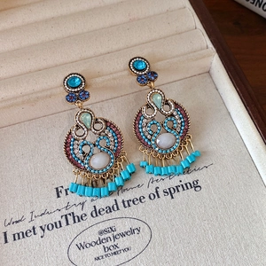 Detail of bohemian drop earrings with turquoise beads and multicolor crystals