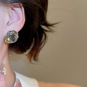 Close-up of elegant clear faceted crystal stud earring on model ear for women