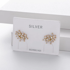 Macro shot of S925 sterling silver golden snowflake earrings with marquise cubic zirconia