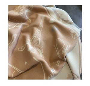 Close-up of khaki cashmere scarf with Eiffel Tower and Paris embroidery texture