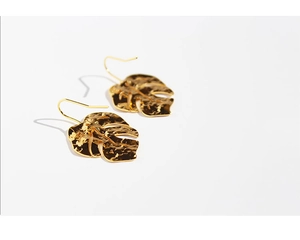 Detailed close-up showing the hammer-textured surface of golden monstera leaf earrings