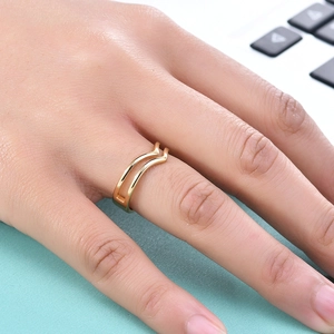 Detail view of a 5mm gold hollow double-V wave stainless steel ring on a model's finger
