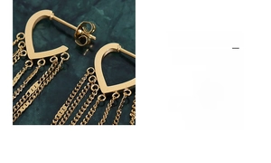 Detailed macro shot of 18k gold plated heart tassel earrings with dangling chains