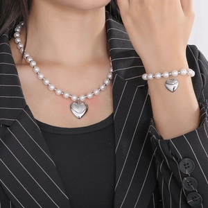 Détail de parure collier et bracelet en perles avec pendentif cœur sur mannequin