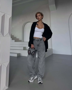 Street style shot of wide-leg washed gray jeans paired with a black shirt and sneakers