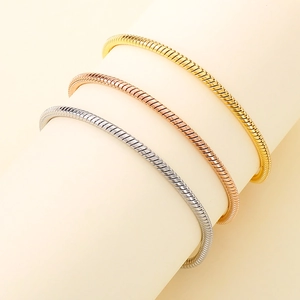 Detailed close-up of gold, rose gold and silver snake bone chain bracelets set