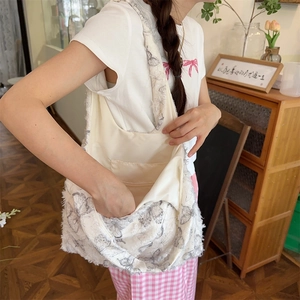 Detail view of canvas tote bag with butterfly print and frayed edges and inner pocket