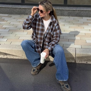 Camicia a quadri marrone casual con jeans a gamba larga e occhiali da sole alla moda