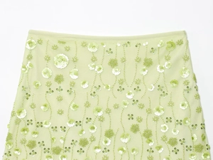 Close-up of pistachio green mesh skirt featuring intricate floral beadwork and sequins