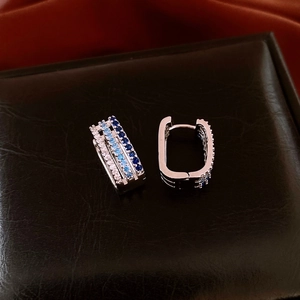 Detail of square silver hoop earrings featuring blue and white gradient zircon stones