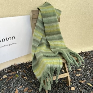 Detailed view of thick striped scarf texture with long fringe on a wooden chair