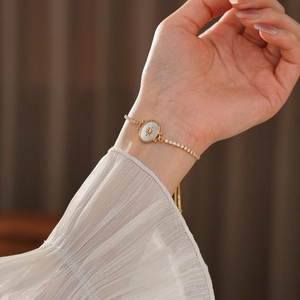 Détail d'un bracelet plaqué or 18 carats avec nacre blanche et motif étoile élégant