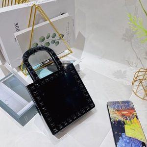 Detailed view of mini black PVC jelly handbag featuring stylish gold stud accents