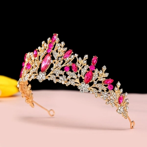 Detail of golden bridal crown with pink crystals and clear rhinestones on black and pink background