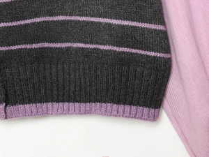 Detailaufnahme von gestreiftem Strickstoff mit Rippstricksaum in Grau- und Lilatönen