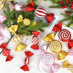 Variety of shiny red and gold candy-shaped Christmas tree hanging ornaments on white fur