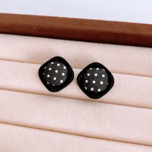 Chic retro polka dot fabric stud earrings with black velvet rhombic trim on display
