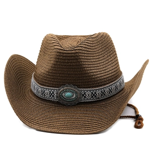 Close-up of brown straw cowboy hat with ethnic geometric band and turquoise stone detail