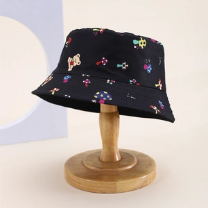 Detailed view of black kids bucket hat with colorful mushroom and teddy bear prints