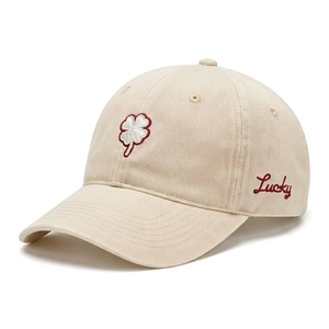 Detailed view of beige cotton baseball cap with four-leaf clover and red Lucky embroidery