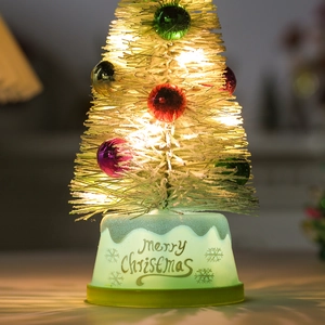 Mini lighted Christmas tree with colorful ornaments and glowing Merry Christmas base