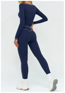 Détail des coutures contrastées blanches sur un ensemble de yoga bleu marine à manches longues