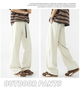 Detalle de pantalones de exterior crema con cordón ajustable y corte holgado casual