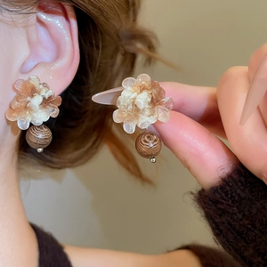 Détail de boucles d'oreilles fleurs en résine rétro avec perles en bois foncé