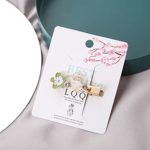 Detail of white cat and green flower enamel hair clip with small rhinestones