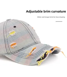 Close-up of distressed denim baseball cap with rainbow stripes and frayed hole details
