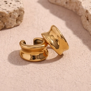Vue macro d'une bague d'oreille en acier inoxydable doré 18K sur pierre texturée