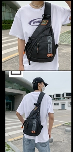 Detail van een zwarte nylon crossbodytas met oranje ritsen en labels in militaire stijl