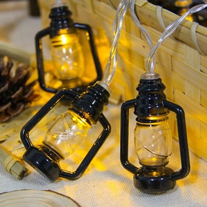 Detail of warm white LED string lights with vintage kerosene lamp design and rustic decor