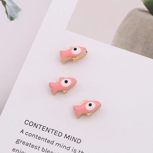 Detailed view of pink enamel fish charms with gold plating and evil eye beads