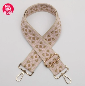 Detail of pink and beige geometric woven wide shoulder strap with gold metal swivel hooks
