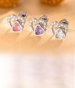 Detail of heart zircon cartilage studs in pink, purple, and white with silver screw backs