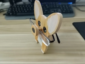 Detailed view of handmade wooden Corgi eyeglasses holder on a desk with glasses