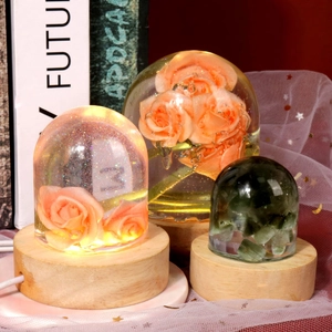 Detailed view of resin art night lights with floral specimens on round wooden bases