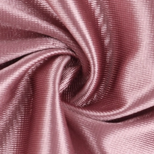 Macro shot of elegant dusty pink satin fabric with smooth texture and luxury silk drape